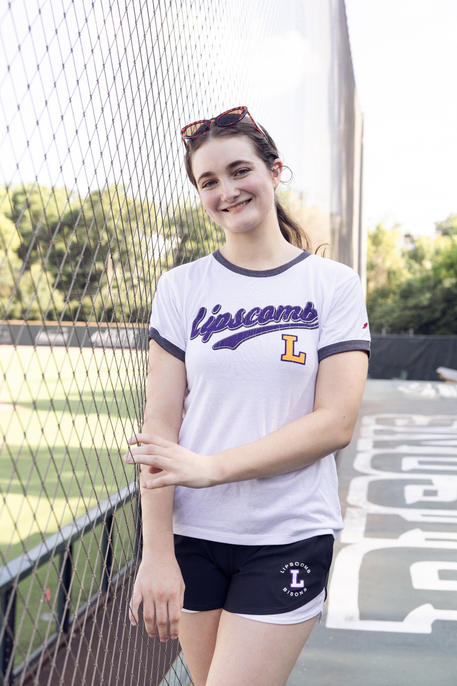 Person wearing a 'Lipscomb' t-shirt and shorts on a sports court